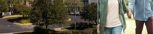Photo of a man and a woman walking in front of an apartment exterior with the text senior affordable apartments for ages 55 plus