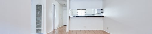 A large empty room with a tiled floor and white walls.