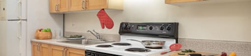A kitchen with wooden cabinets and a black stove top.