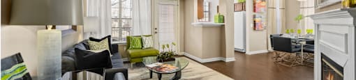 Spacious living room and dining room with wood-burning fireplace with glass doors, ceiling fan, 9-foot ceilings and wood grain plank flooring at The Lanesborough Apartments in Houston.