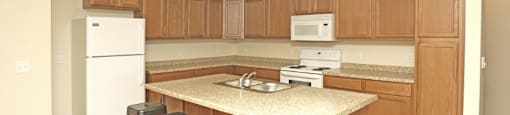 A kitchen with wooden cabinets and a white fridge.