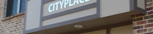 A building with a sign that says Cityplace and the number 210  at City Place Apartments Denton, TX 