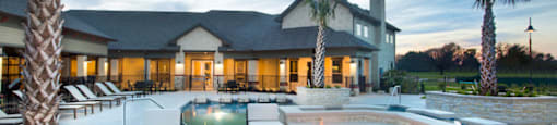 a swimming pool with a fire pit in front of a house