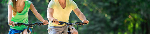 a man and a woman riding bikes in the park