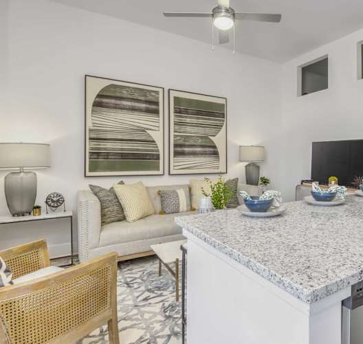a kitchen with a counter top next to a living room