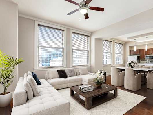 A living room with a white couch and a brown coffee table.