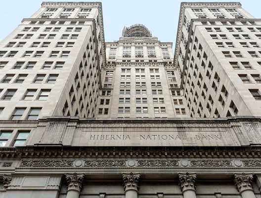 The Hibernia National Bank building is a tall structure with many windows.