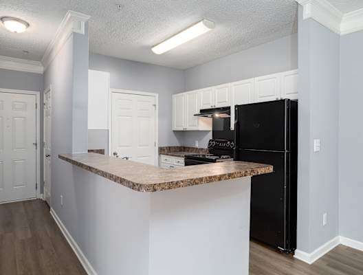 a kitchen with an island and a black refrigerator