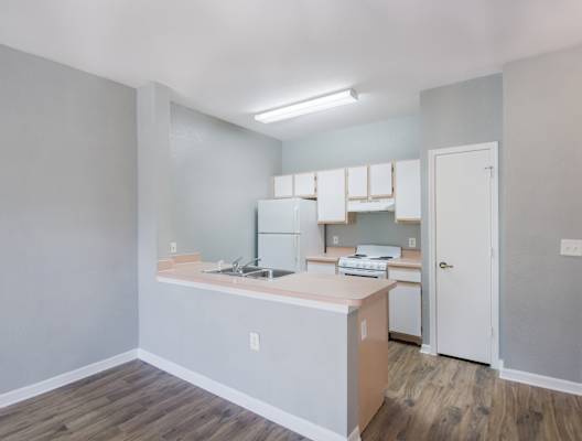 a kitchen with a white refrigerator freezer next to a white stove top oven