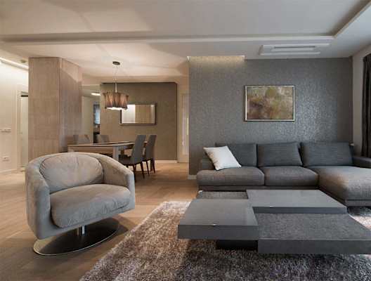 A modern living room with a grey sofa and a grey armchair.