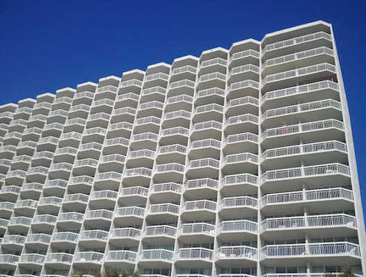 an apartment building with a blue sky above it