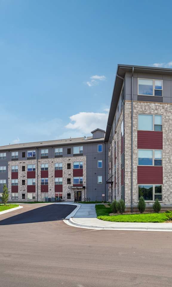 A large multi-story building with a parking lot in front.