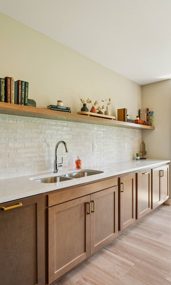 A kitchen with wooden cabinets and a stainless steel refrigerator.
