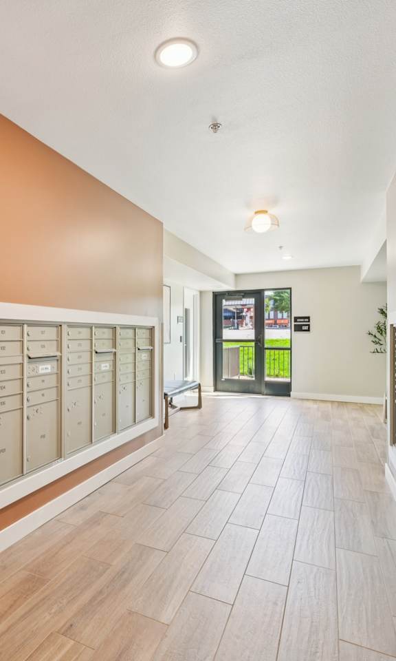 A hallway with a white counter and brown cabinets.