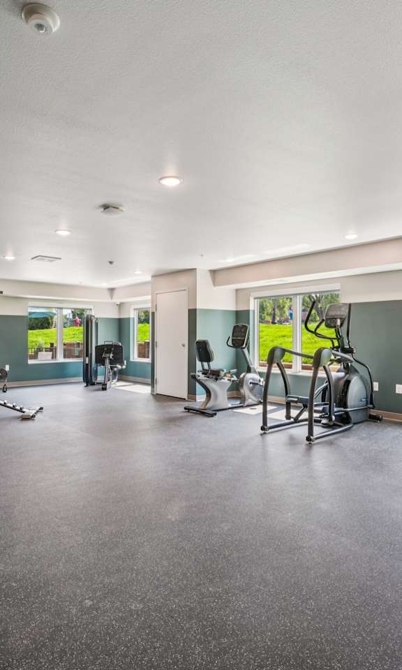 A spacious gym with treadmills, elliptical machines, and other exercise equipment.
