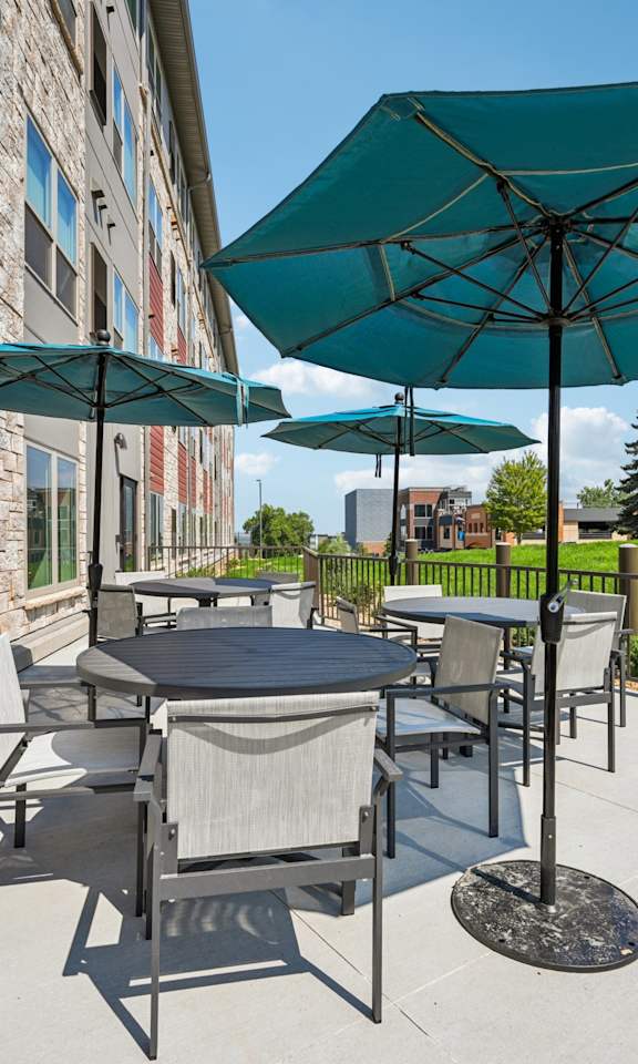 A patio with a table and chairs under a large umbrella.