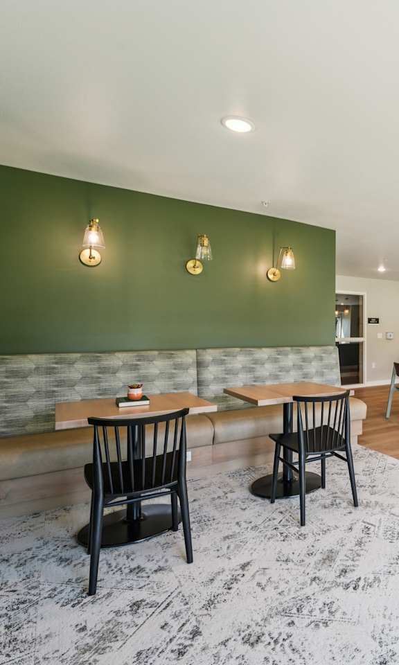 A room with a green wall and a grey carpet.