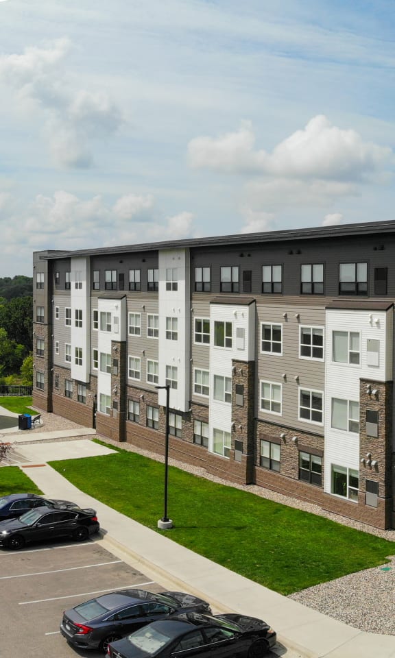 an aerial view of an apartment building with cars parked in a parking lot