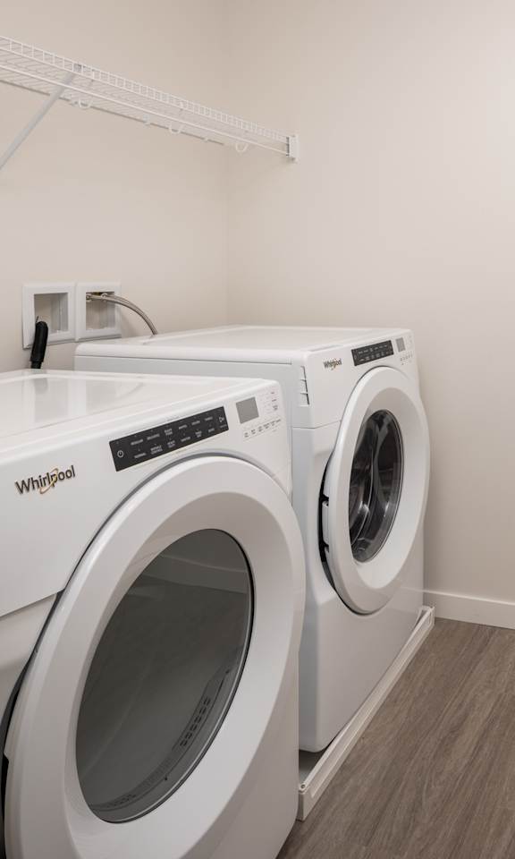 A white washing machine and dryer in a laundry room.