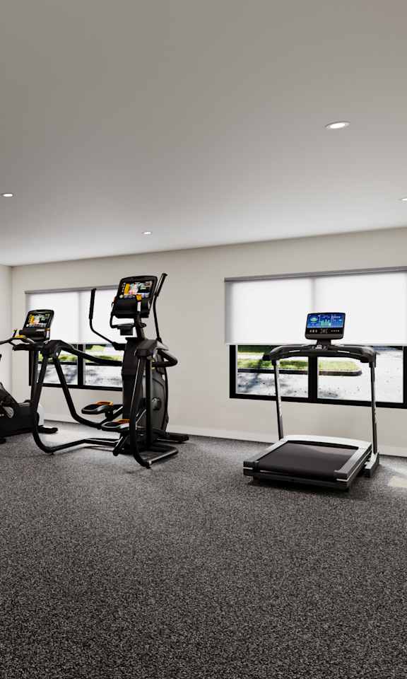 A spacious gym with a variety of equipment including a treadmill, weights, and a bench press.