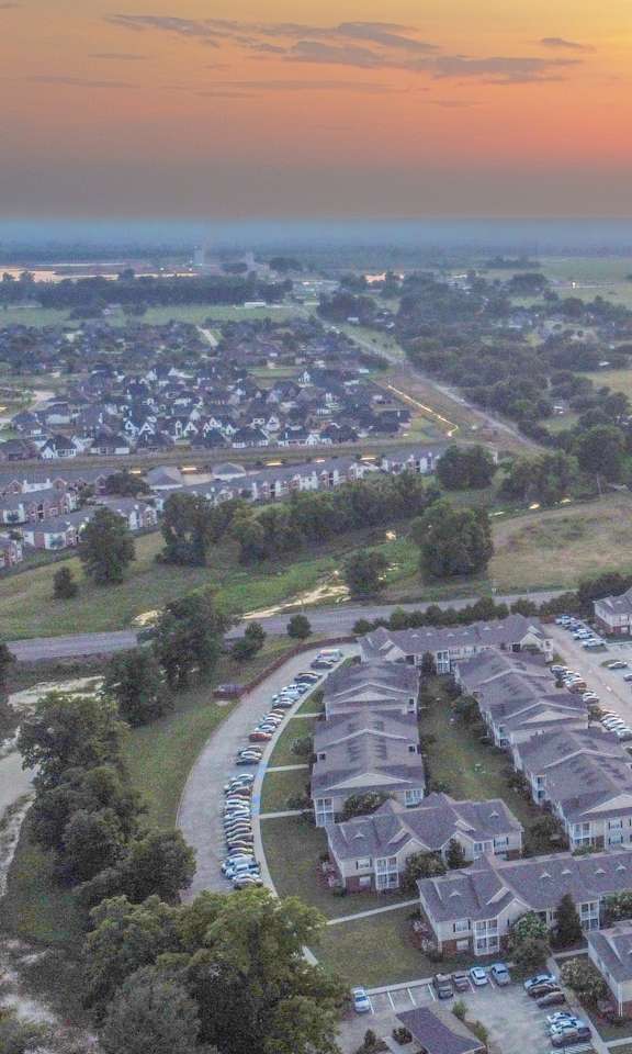 an aerial view of a neighborhood with a sunset in the sky