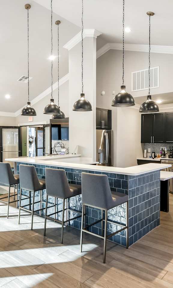 a kitchen with a bar and a living room with a tv
