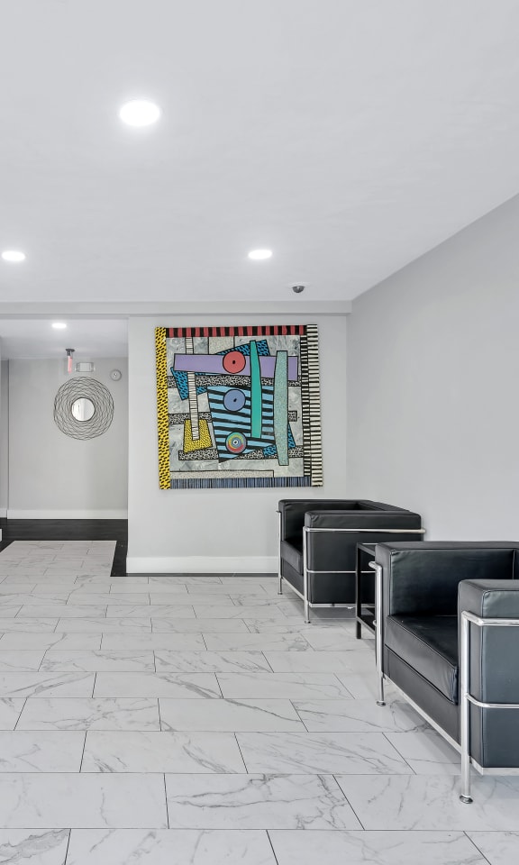 a lobby with white walls and a colorful painting on the wall