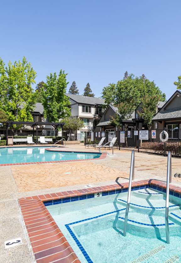 A pool with a slide and a hot tub.