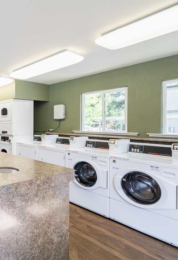 A laundry room with a washer and dryer on both sides of a central island.