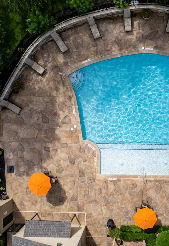 An aerial view of a swimming pool surrounded by a stone wall.