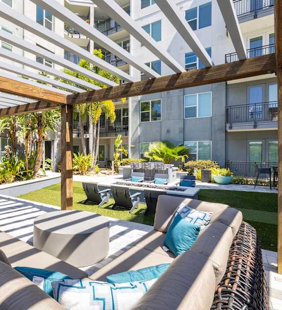 A modern outdoor seating area with a pool and lounge chairs.