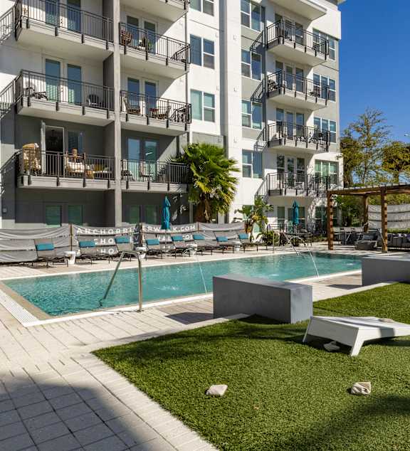 A large white building with a pool in front.