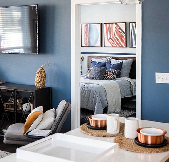 a bedroom with blue walls and a bed in the background