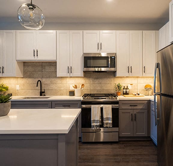 a kitchen with white cabinets and stainless steel appliances