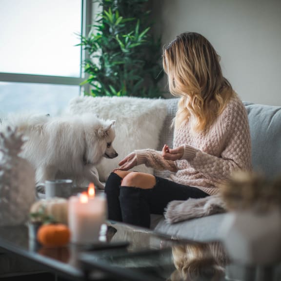 a woman sitting on a couch with her dog
