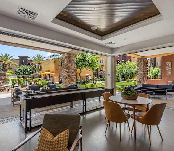a patio with a table and chairs and a pool in the background