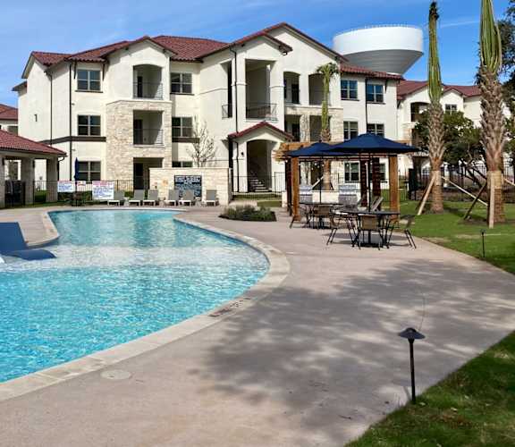 a swimming pool at a resort with a building in the background