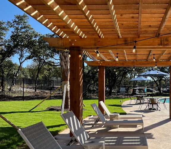 a group of chairs and tables under a wooden pavilion