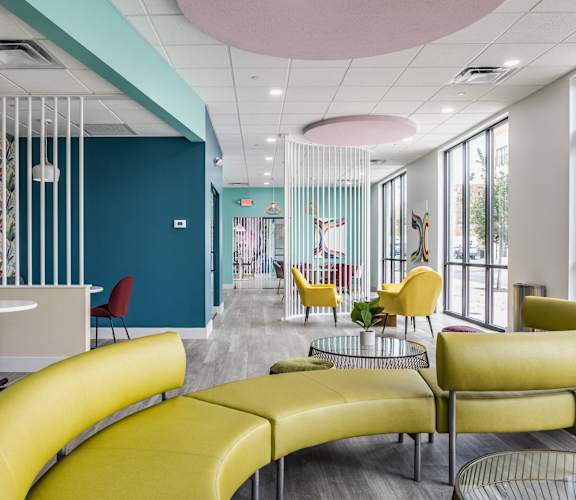 A room with a blue wall and yellow chairs.