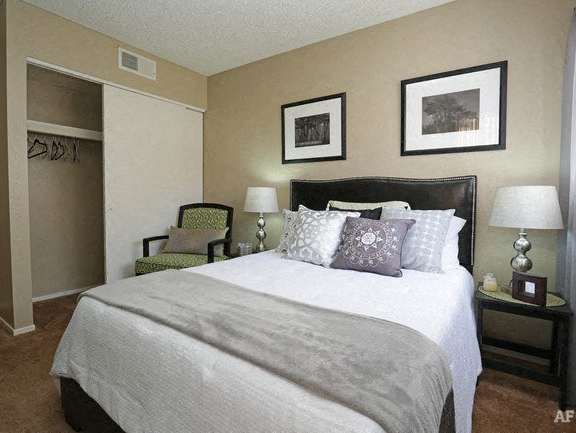 a bedroom with a large bed and a chair