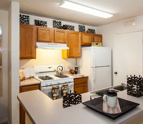 a kitchen with a white refrigerator freezer next to a stove top oven