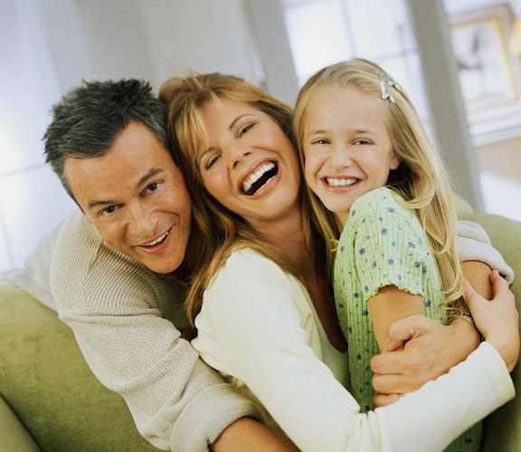 a man and woman sitting on a couch with a little girl