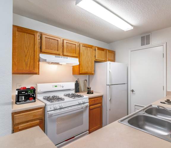 a kitchen with white appliances and wooden cabinets