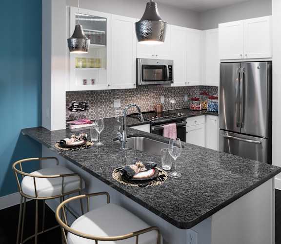 a kitchen with granite counter tops and stainless steel appliances at Gatsby on Ross, Dallas, Texas