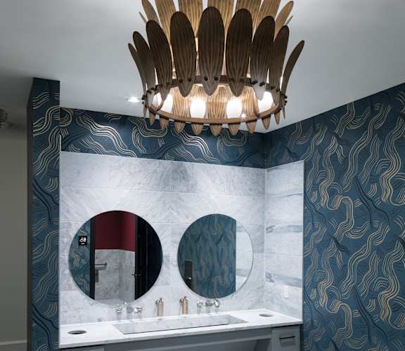 a bathroom with blue and white walls and a sink and a mirror at Gatsby on Ross, Dallas, Texas