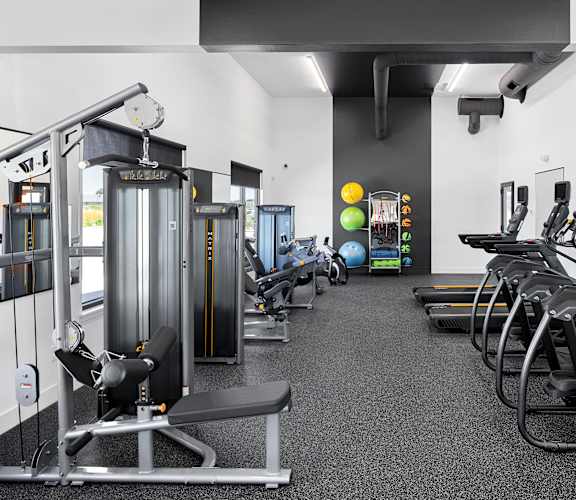 a spacious exercise room with cardio equipment and weights at The Expo, Billings, Montana