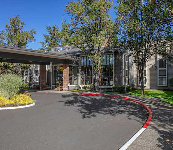 A curved driveway leads to a building with a covered entrance.