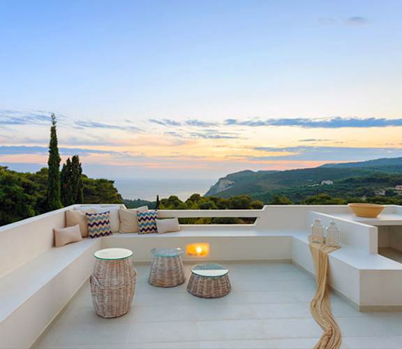 A patio with a table and chairs overlooking a scenic view.