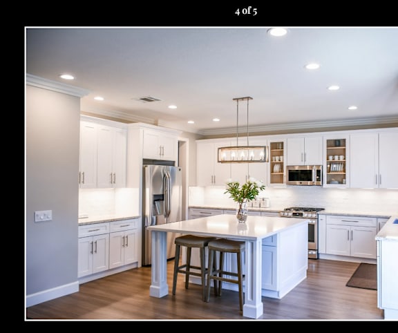 A modern kitchen with white cabinets and a central island.