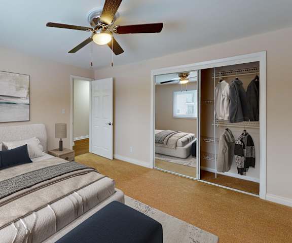 A bedroom with a large bed and a ceiling fan.